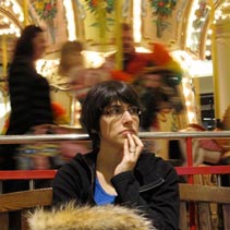 [Elena in front of the carousel]