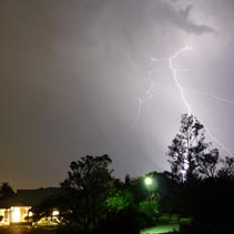[lightning over gum trees and house in the Brisbane suburbs]
