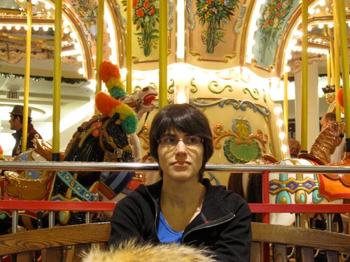 [Elena in front of the carousel]