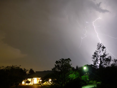 [lightning over gum trees and house in the Brisbane suburbs]